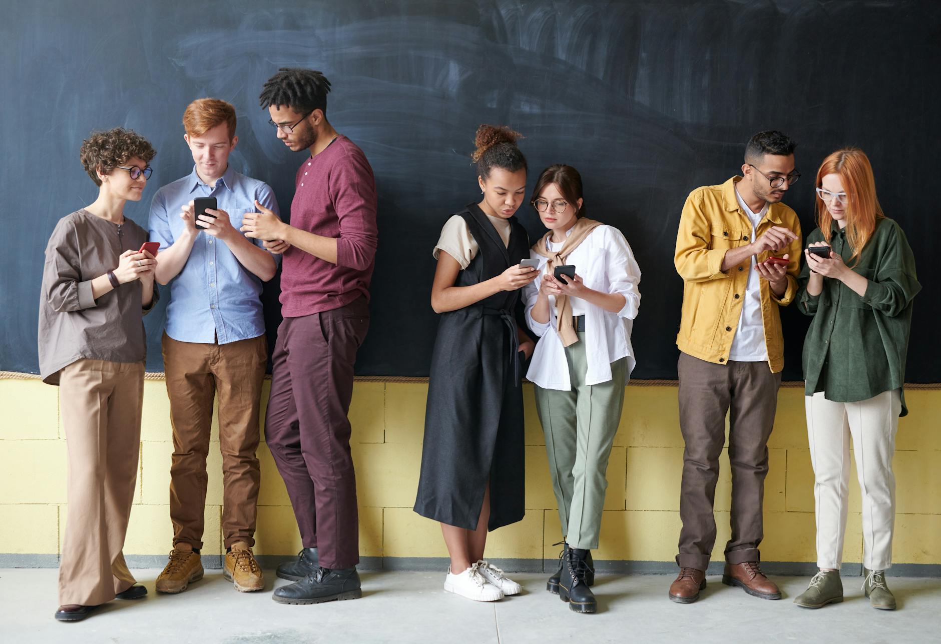 photo of people standing near chalk board