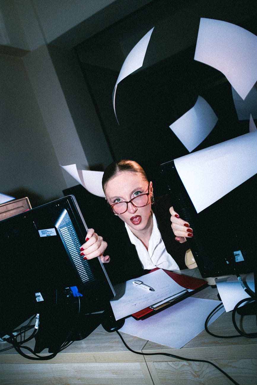stressed office worker surrounded by paperwork chaos