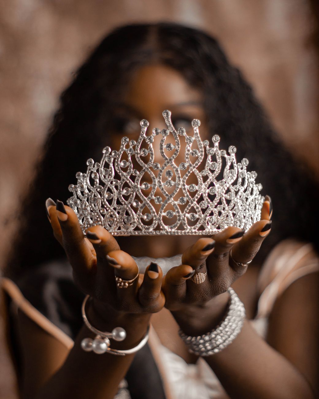 elegant woman holding a glittering crown
